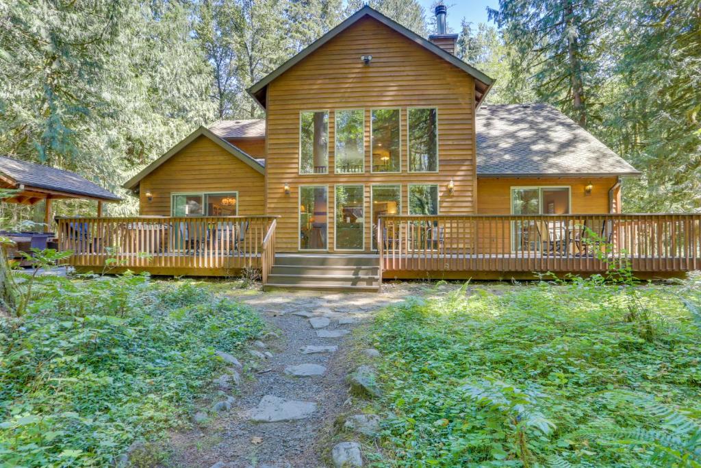 une maison en bois avec une terrasse couverte et une terrasse dans l'établissement Salmon River Lodge, à Welches