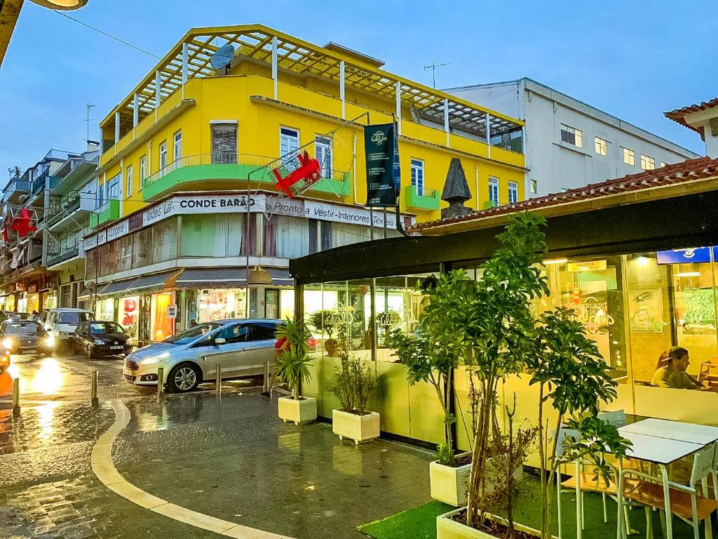 una calle de la ciudad con edificios y coches en la carretera en Lar dois coracões en Lisboa