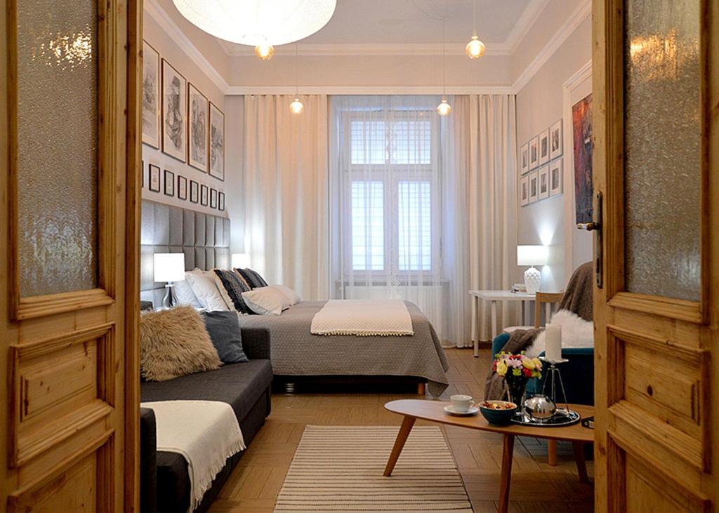 een woonkamer met een bed en een bank in een kamer bij Art Apartments w centrum Krakowa (Śródmieście, Stradom) in Krakau