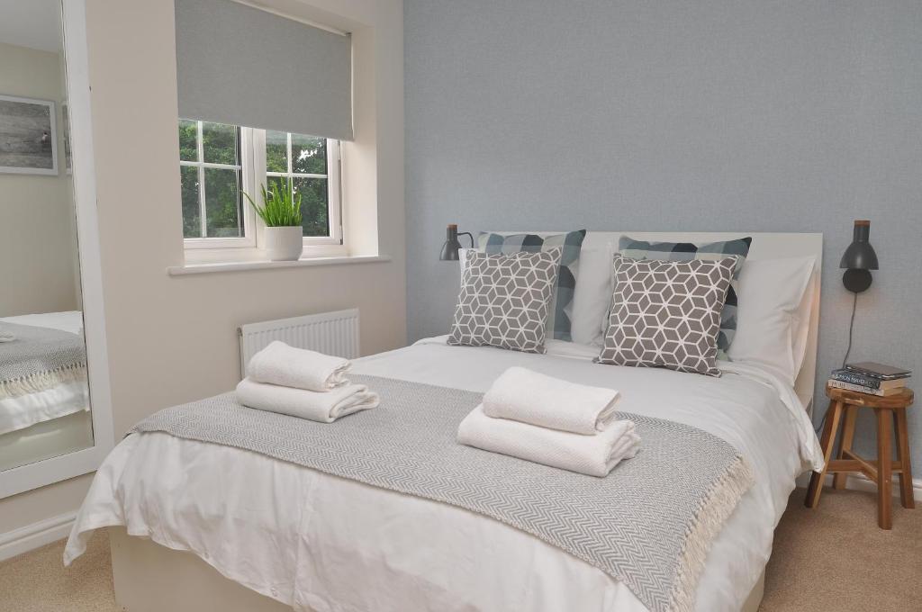 um quarto com uma cama branca com almofadas e uma janela em Glebelands em West Monkton