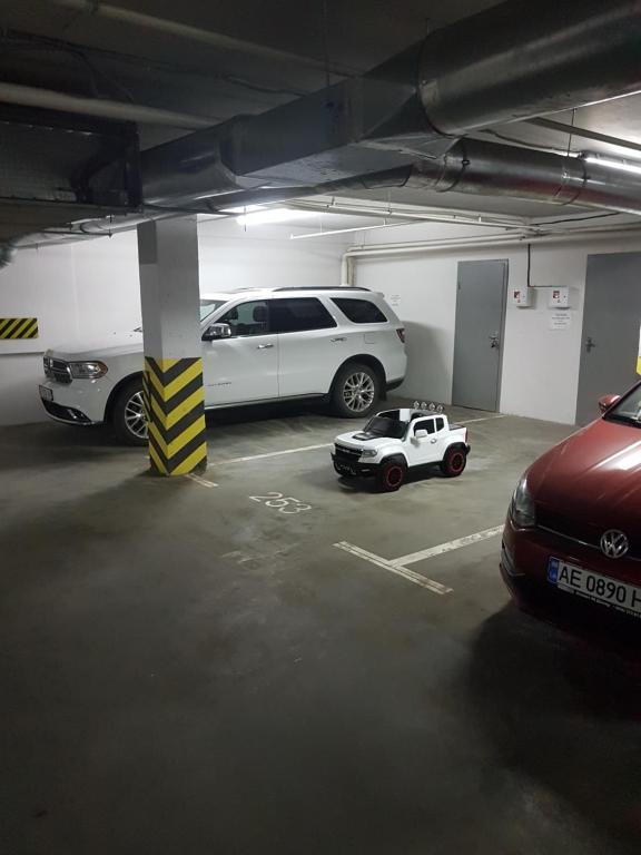 a parking lot with two cars and a small car at ACCOMMODO192 in Dnipro