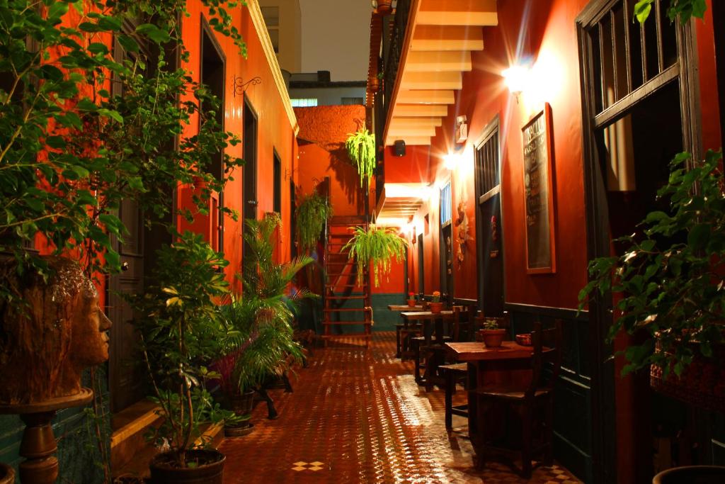 a narrow alley with tables and potted plants in a restaurant at KACLLA, The Healing Dog Hostel in Lima