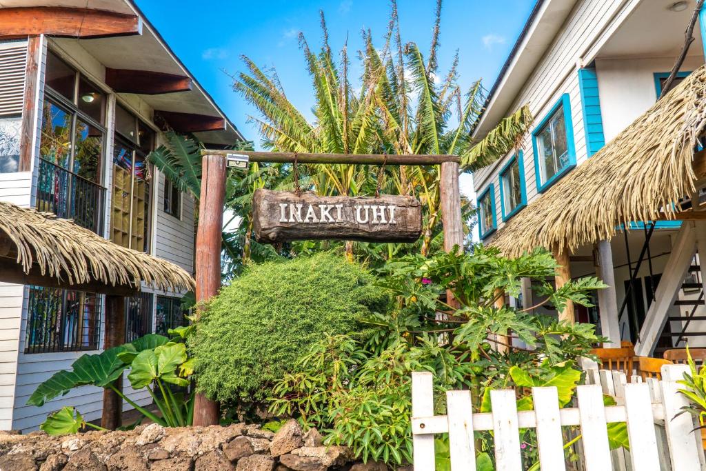 a sign in front of a house with a plant out at Inaki Uhi Hotel in Hanga Roa