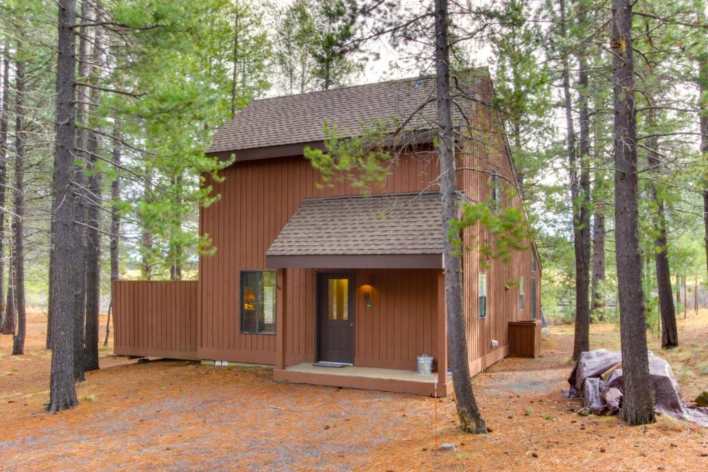 a small red building in the middle of a forest at 5 Butternut in Sunriver