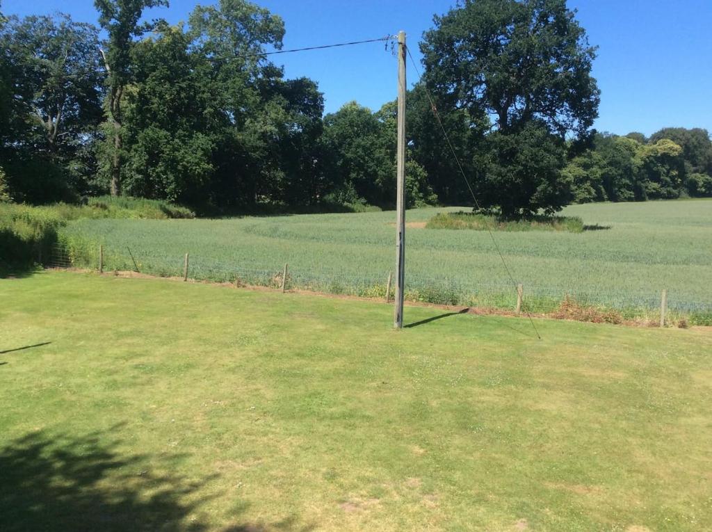 un poste telefónico en medio de un campo en Woodland View - a place to escape en Swynnerton