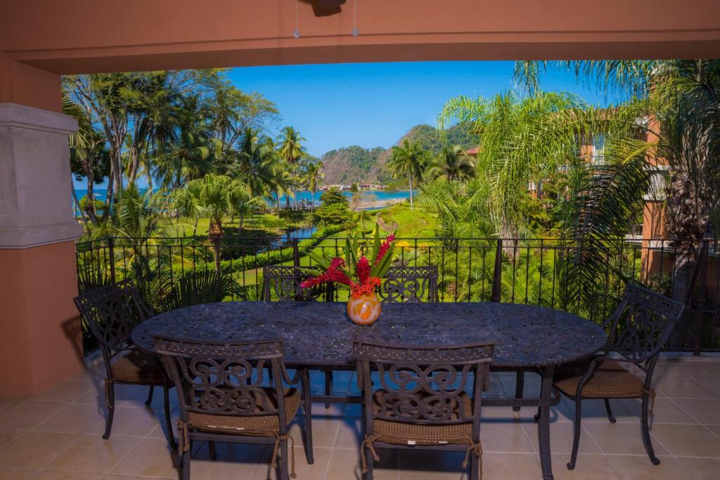 comedor con mesa, sillas y vistas en Los Suenos Resort Bay Residence 7C, en Herradura