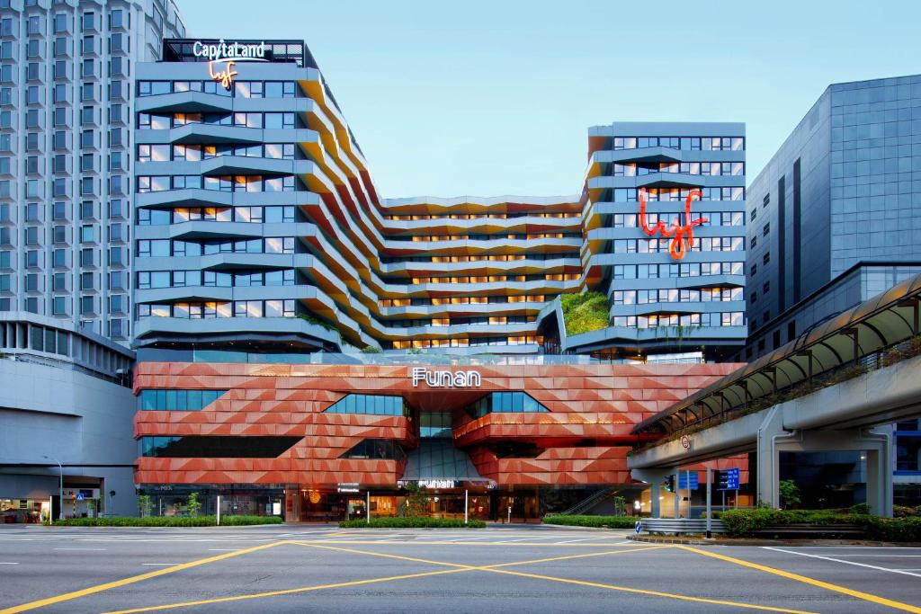 a large building with a parking lot in front of it at lyf Funan Singapore in Singapore