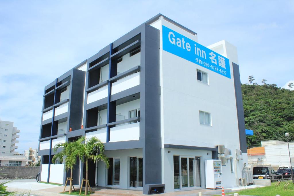 un gran edificio blanco con un cartel azul en Gate in Nago en Nago