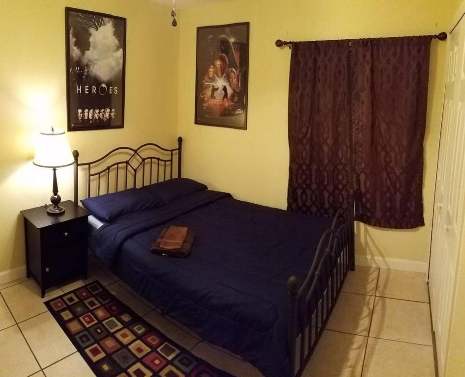 um quarto com uma cama com um edredão azul em B Private Bedroom em Orlando