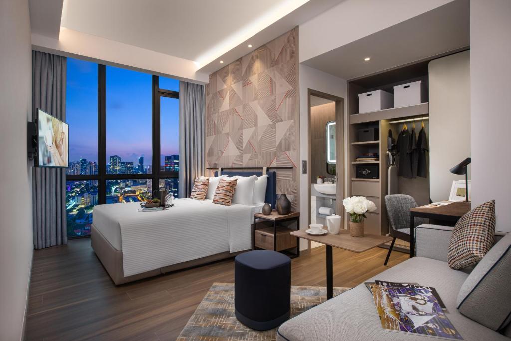 a bedroom with a bed and a living room at Citadines Balestier in Singapore