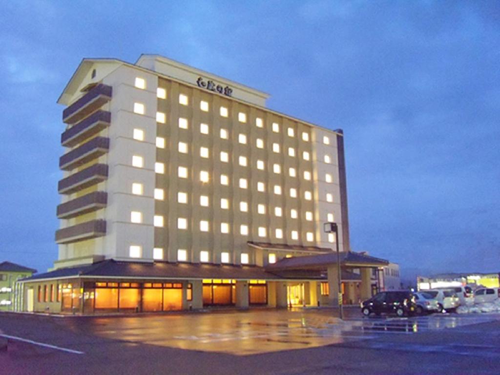 un edificio de hotel con luces encendidas en un aparcamiento en Route Inn Grantia Himi Wakuranoyado en Himi