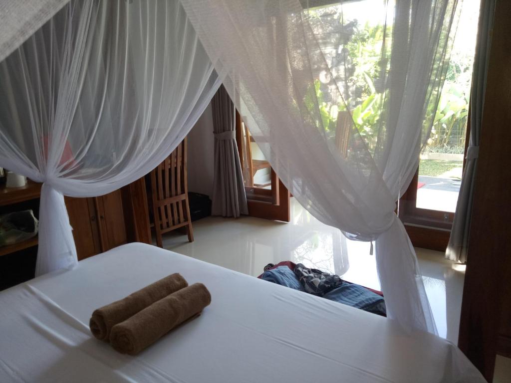 Un pat sau paturi într-o cameră la Suryadina Guest House