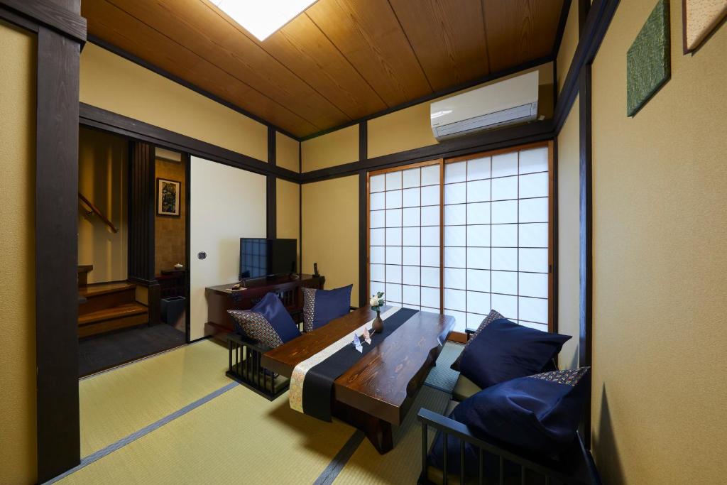 ein Wohnzimmer mit einem Tisch und einem Sofa in der Unterkunft Rinn Yasaka Kodaiji in Kyoto