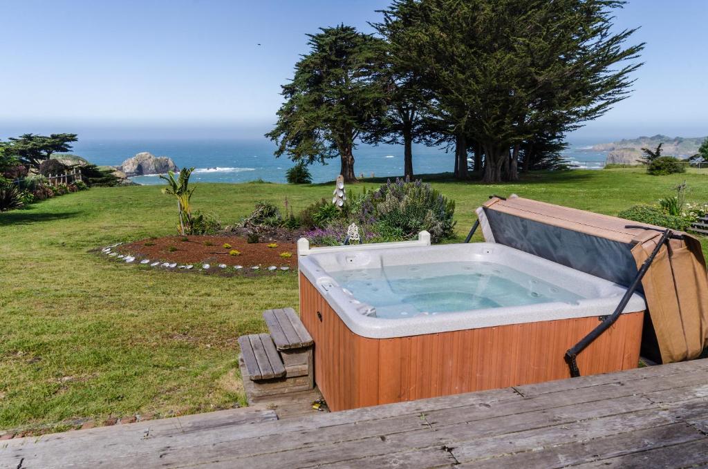 a hot tub on a deck with the ocean in the background at Bella Mare in Elk