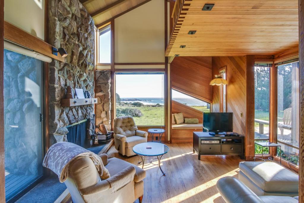a living room with a fireplace and a stone wall at Vista Grande in Sea Ranch
