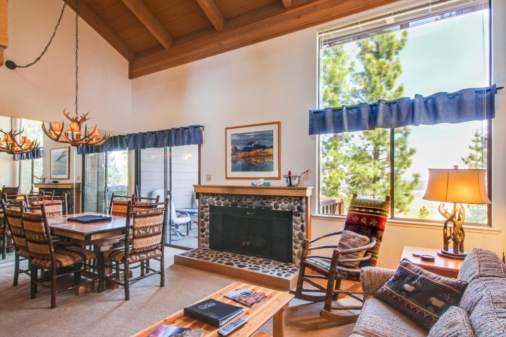 ein Wohnzimmer mit einem Kamin, einem Tisch und Stühlen in der Unterkunft View Condo at Northstar in Truckee