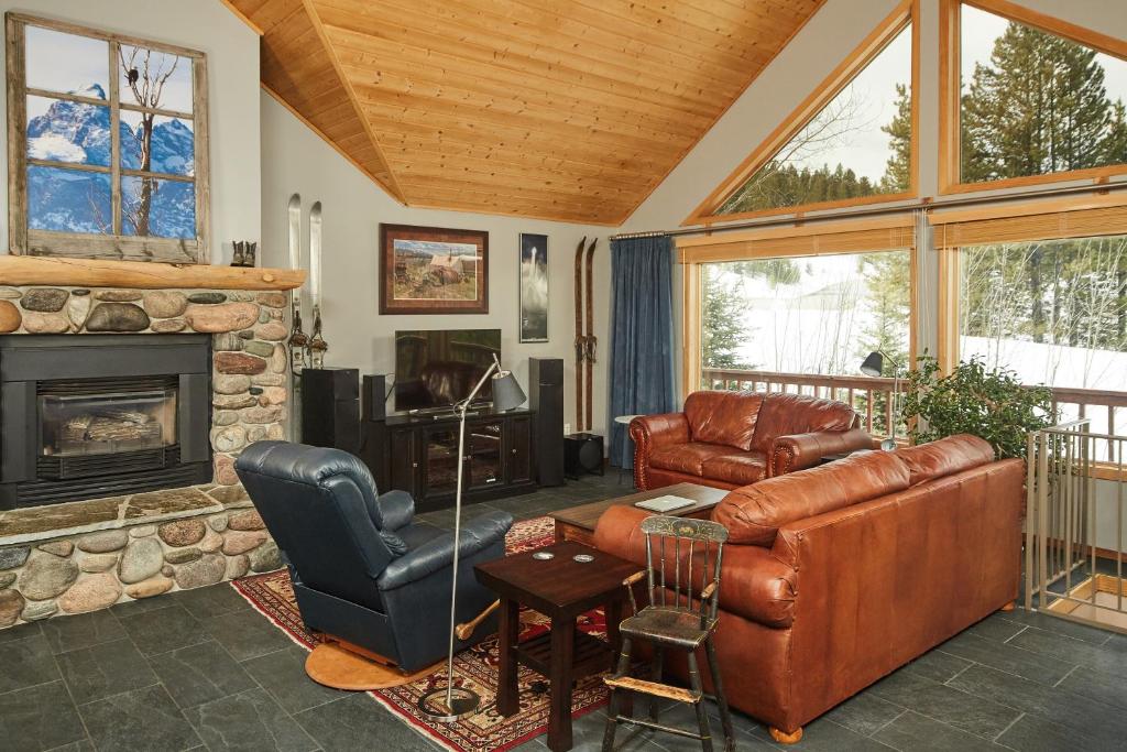a living room with leather furniture and a fireplace at Lone Walker Home in Big Sky