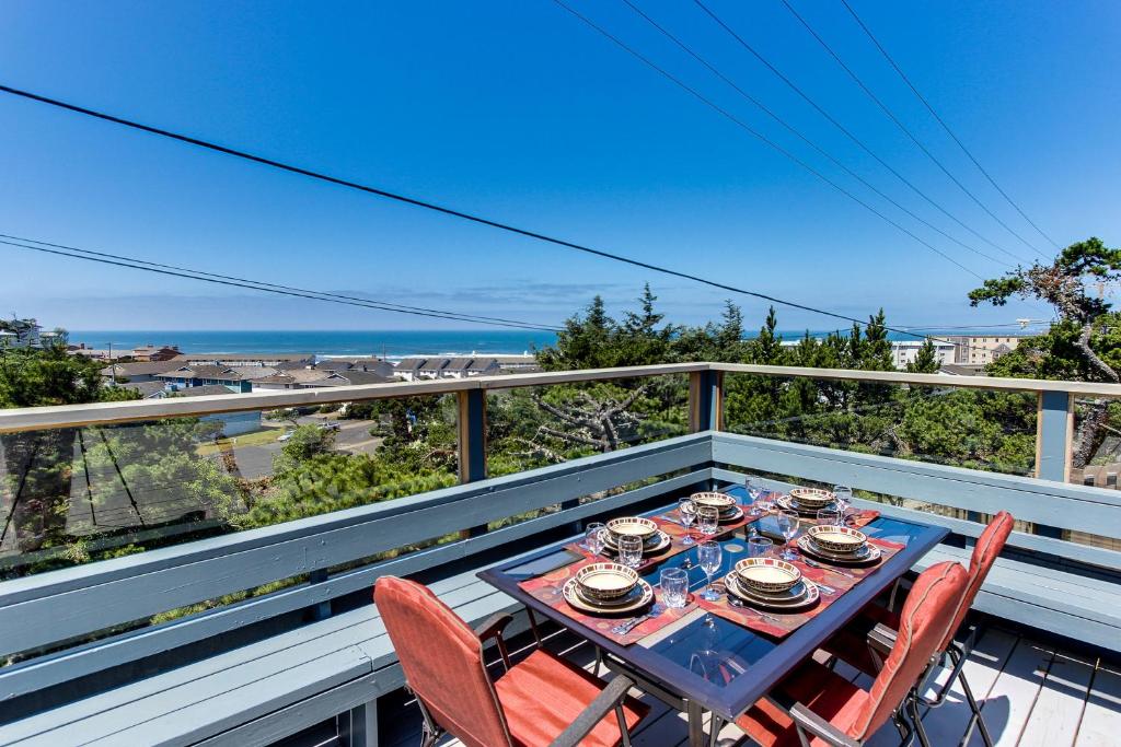 d'une table et de chaises sur un balcon avec vue sur l'océan. dans l'établissement Newport's Cypress Oceanview Home, à Newport