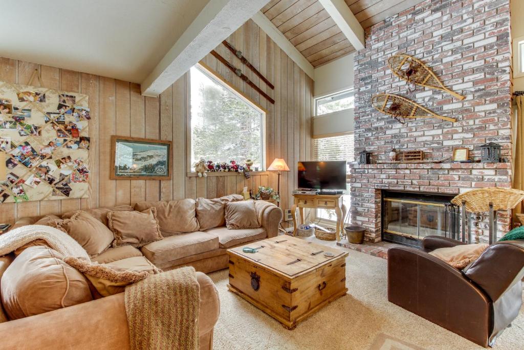 een woonkamer met een bank en een open haard bij Chamonix 100 in Mammoth Lakes