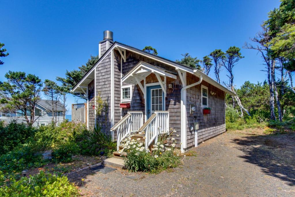 a small house with a blue door and a porch at Oregon Bed n' Beach in Holiday Beach