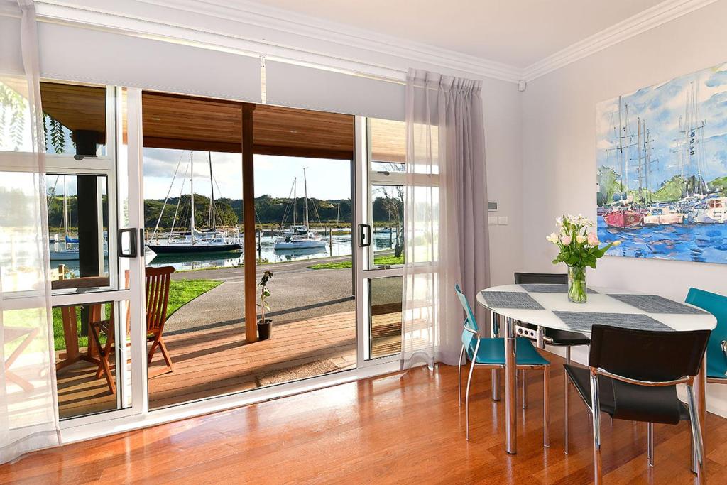 a dining room with a table and a large window at The Weiti Waterfront in Whangaparaoa