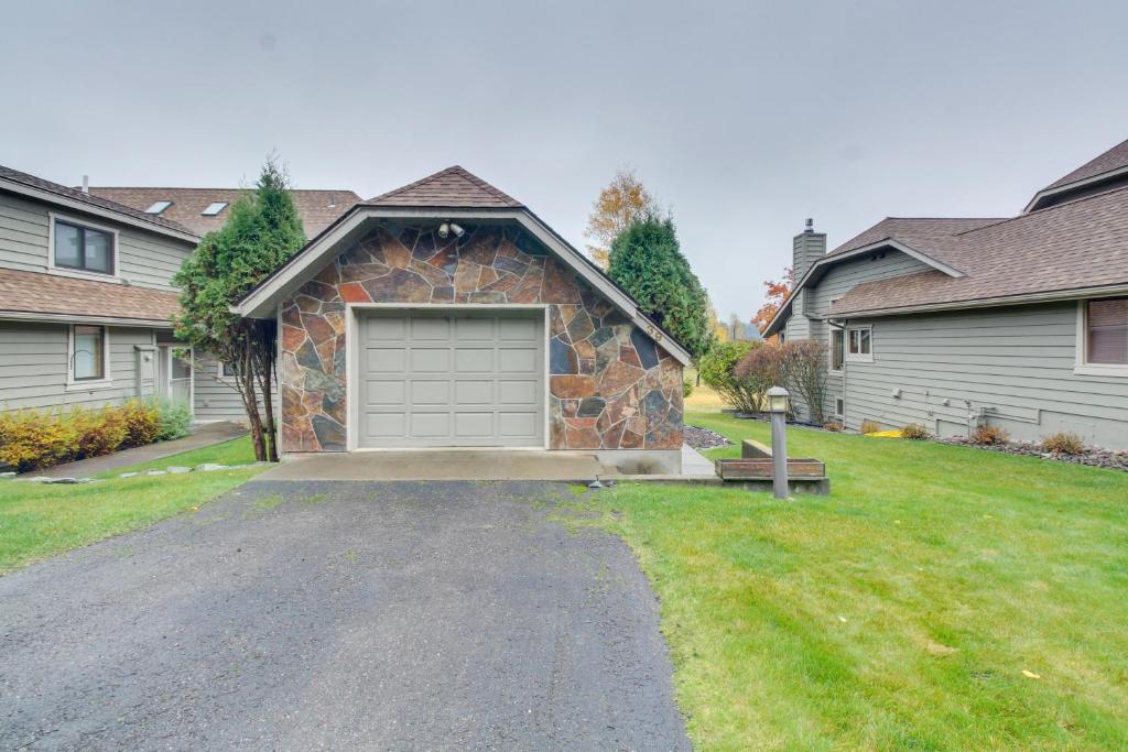 a house with a garage in a yard at Golfer's Villa in Bigfork