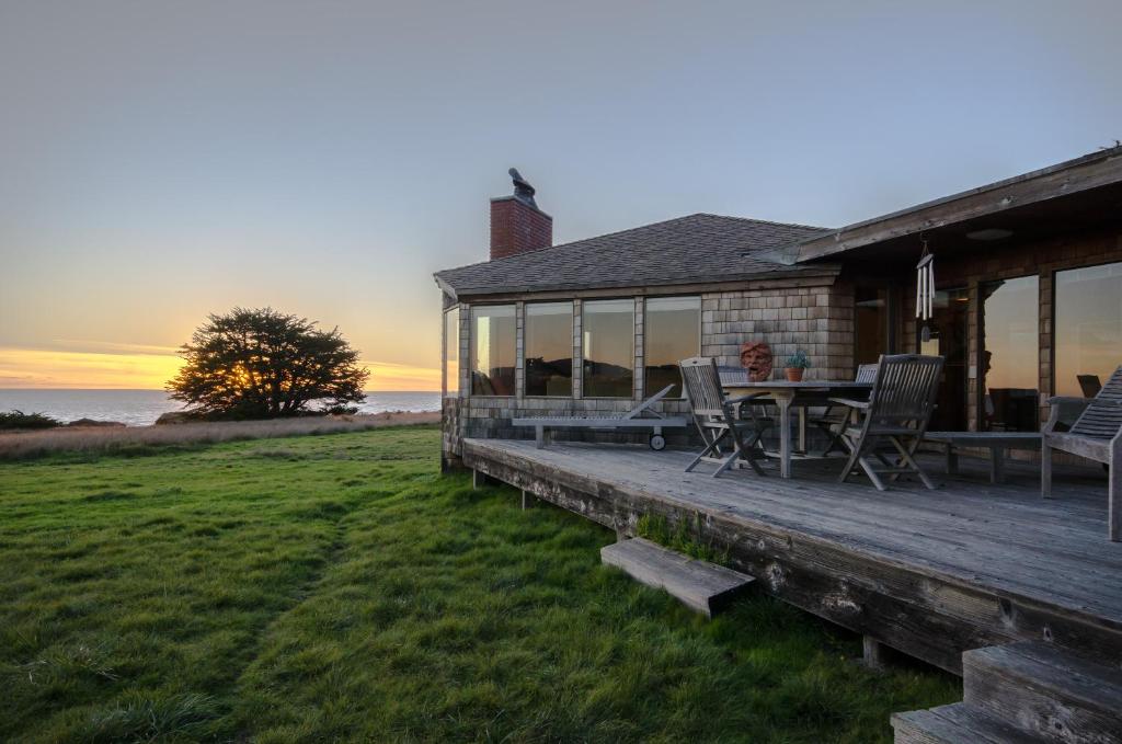 a house with a deck with a table and chairs at Bovill on Shell Beach in Sea Ranch