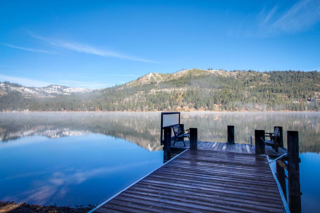 a dock on a lake with mountains in the background at Donner Lakefront Retreat in Truckee