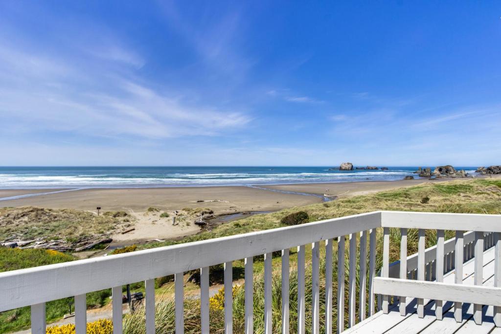 a view of the beach from the balcony of a house at Spindrift Oceanfront Home - The Helm in Bandon