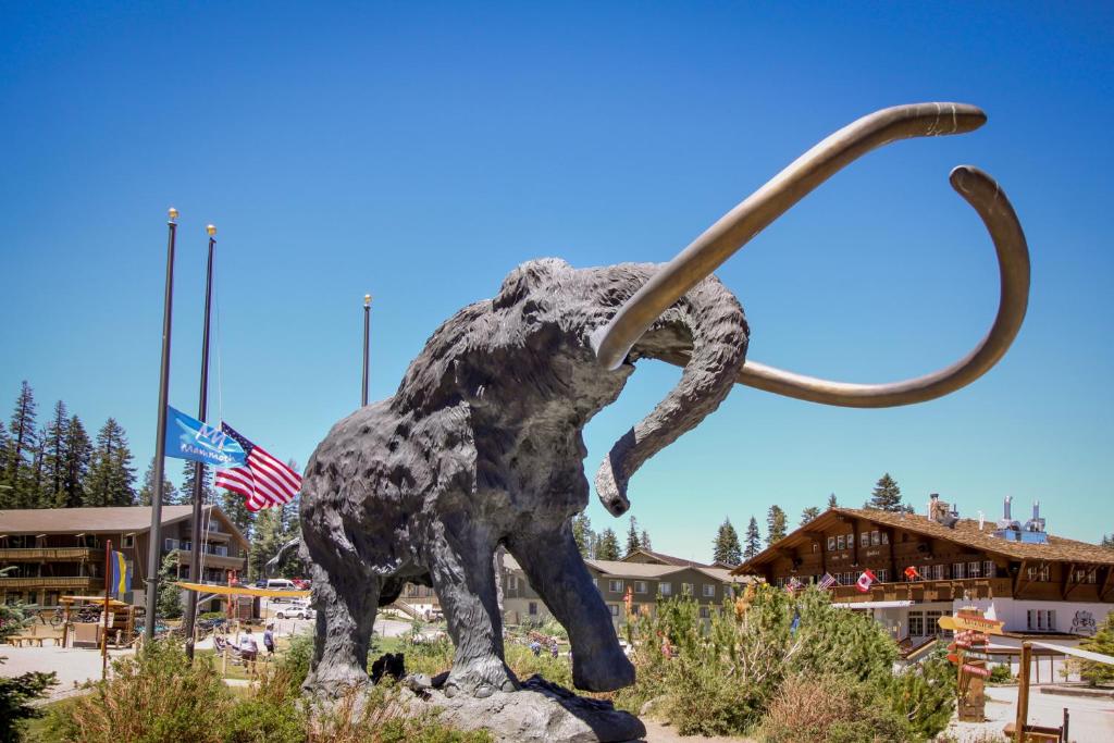 a statue of a dinosaur in front of a building at Mammoth Ski & Racquet 124 in Mammoth Lakes
