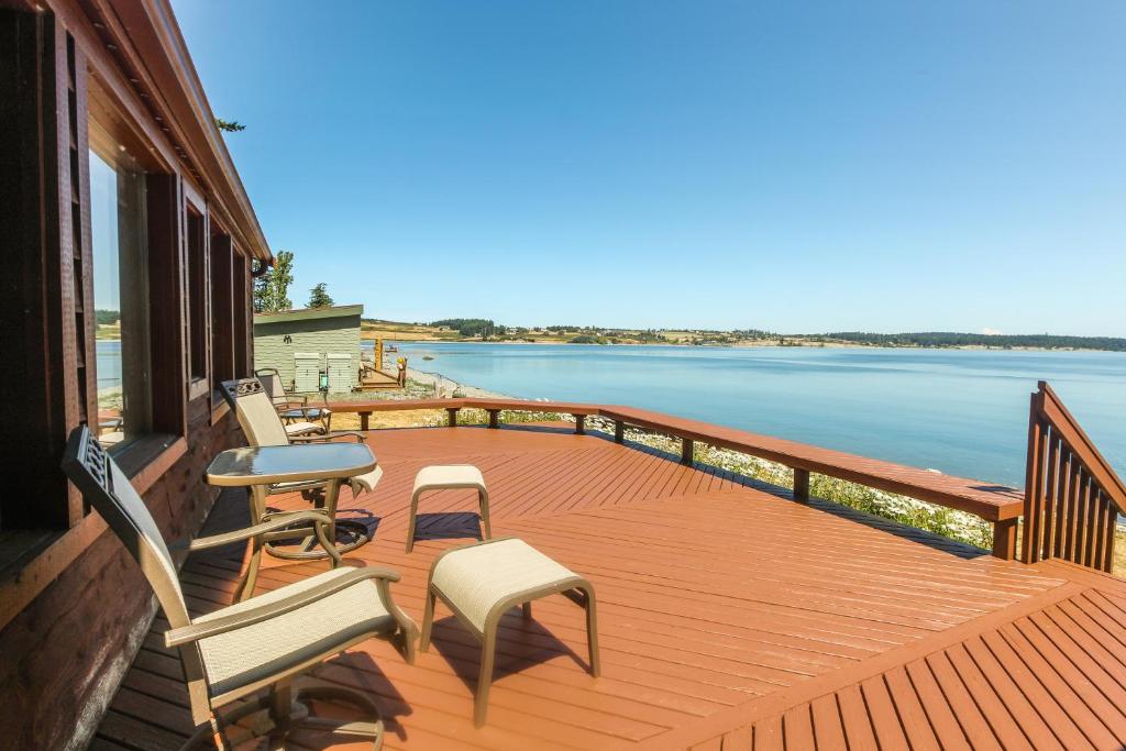 una terraza con sillas y vistas al agua en The Cabin At Penn Cove, en Coveland