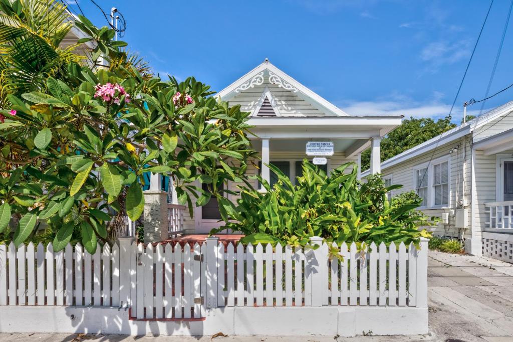 a white picket fence in front of a white house at Leeward Isle in Key West