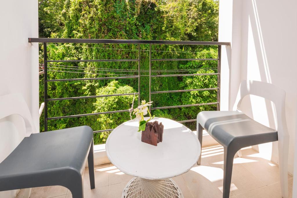 a balcony with a table and two chairs and a window at Sungthong Kamala Beach Resort in Kamala Beach