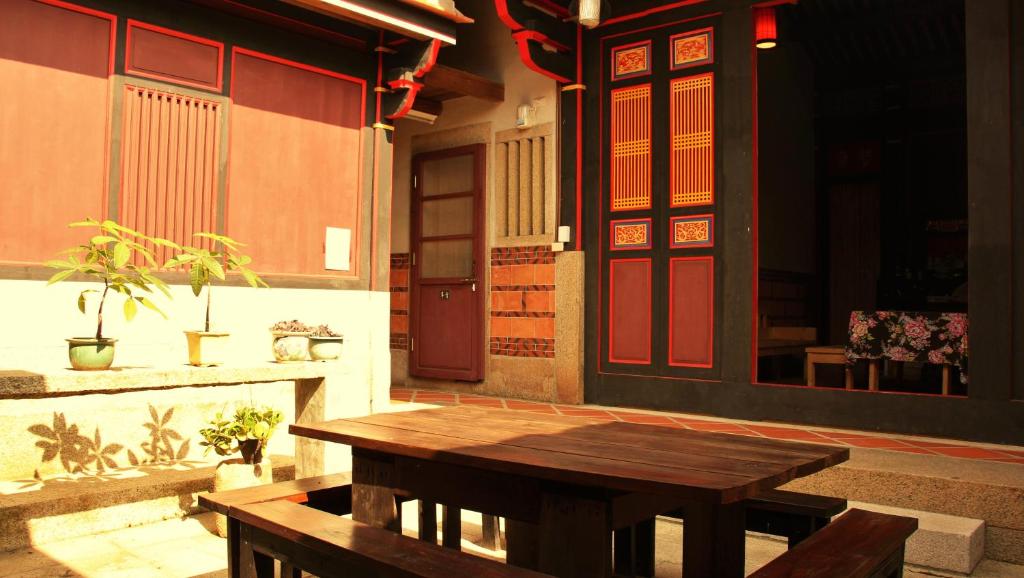 een houten tafel voor een gebouw bij Casa Wisteria in Jincheng