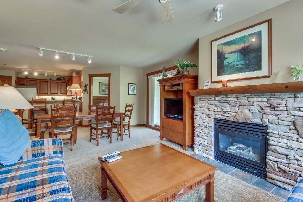 a living room with a fireplace and a dining room at Powderhorn Lodge 223: Pennyroyal Suite in Solitude