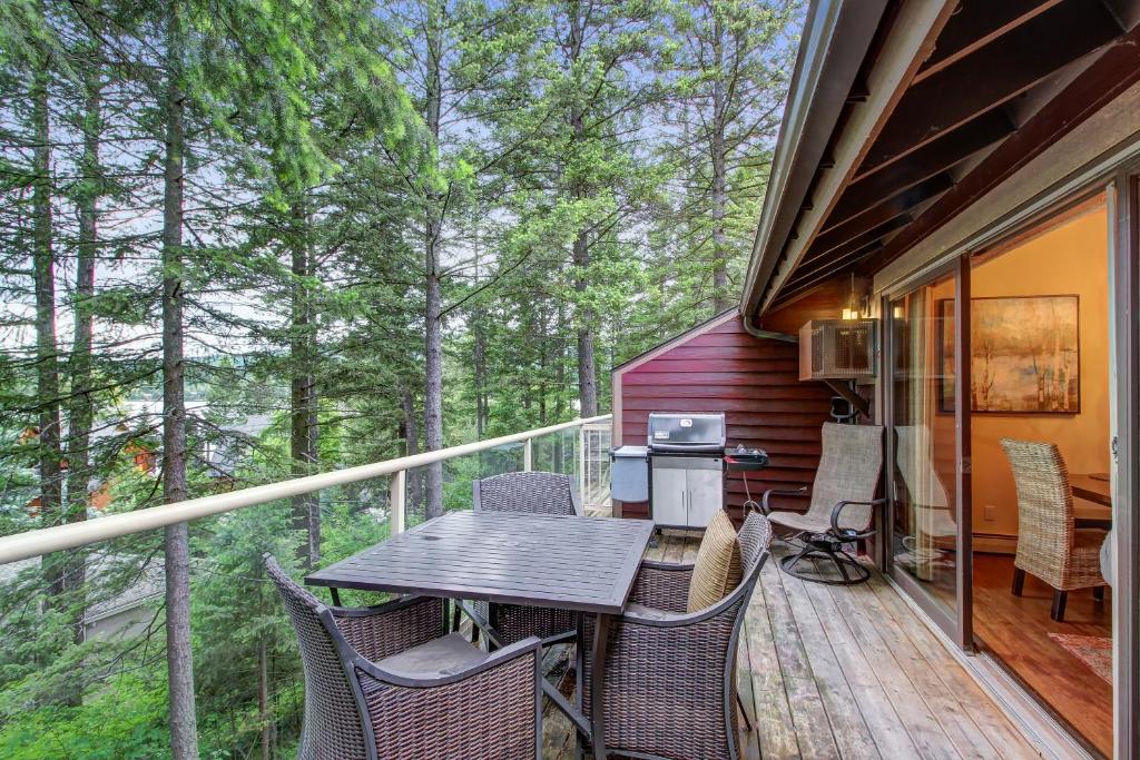 a porch with a table and chairs on a deck at Bay Point Hillside 16B in Whitefish