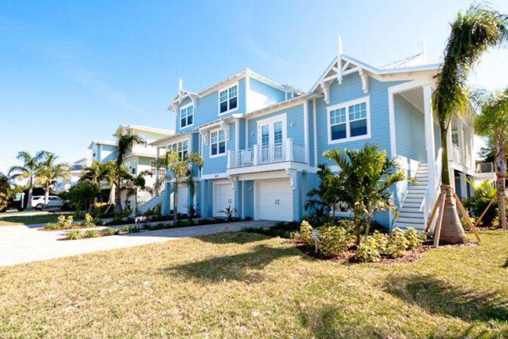 una grande casa blu con palme e un cortile di LaMedeira 305 Unit A a Holmes Beach