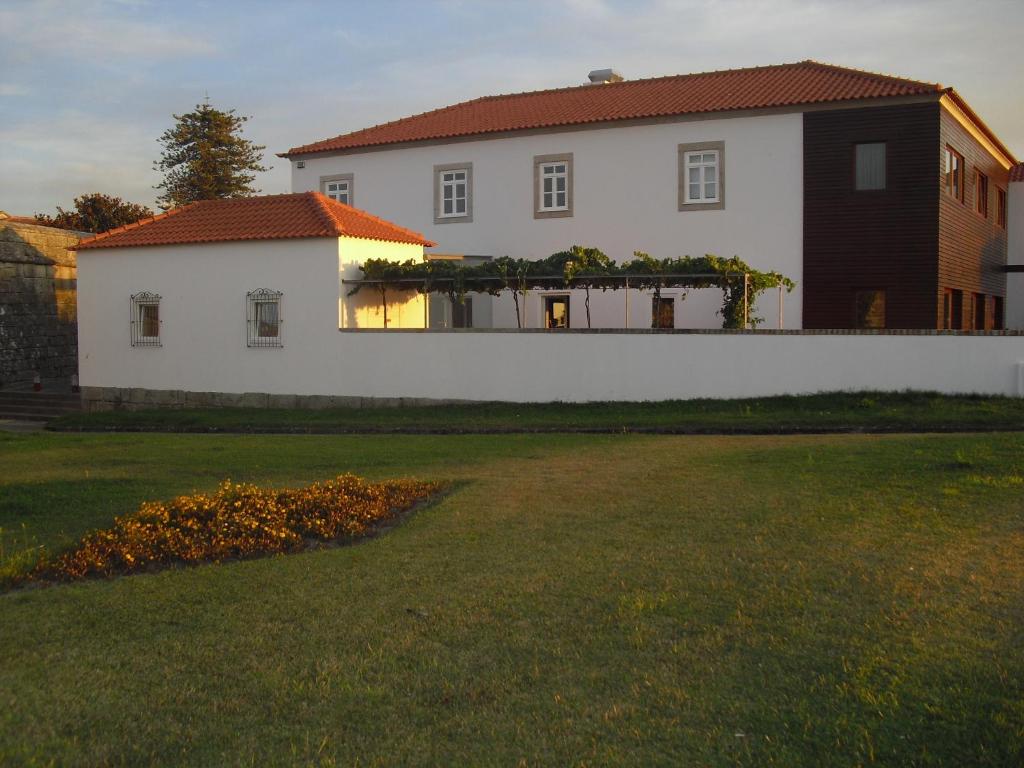 uma casa branca com uma cerca em frente a um quintal em Muralha de Caminha em Caminha