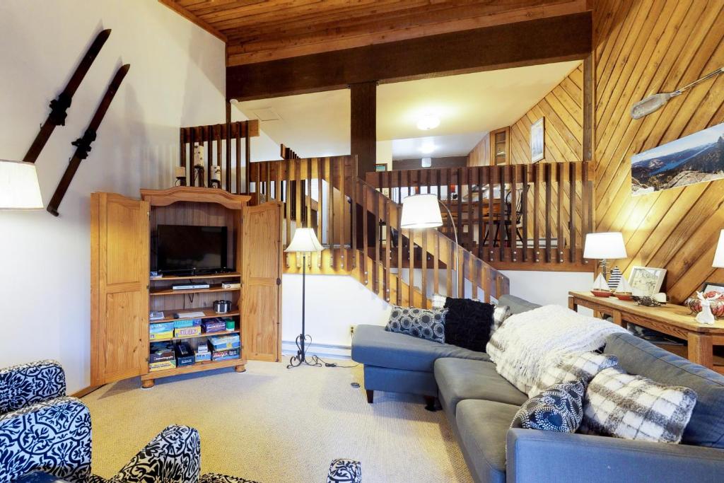 a living room with a blue couch and a staircase at Huntington Lake Condo 12 in Lakeshore