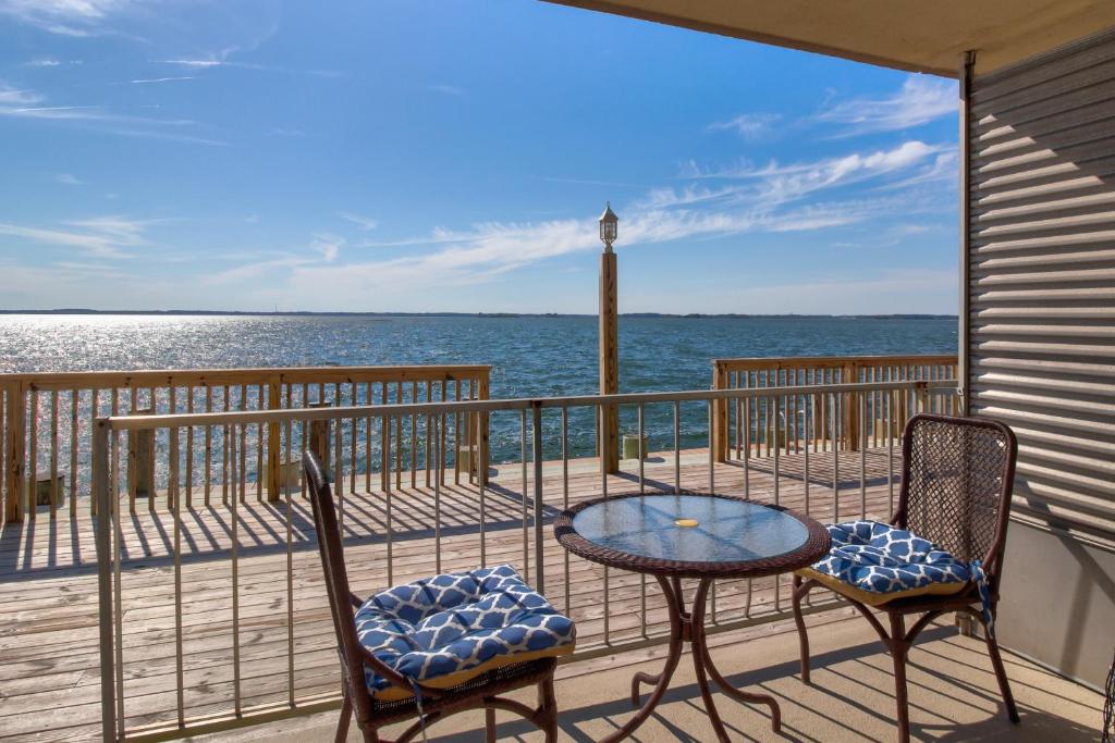 a balcony with a table and chairs and the ocean at Bayside Beauty in Ocean City