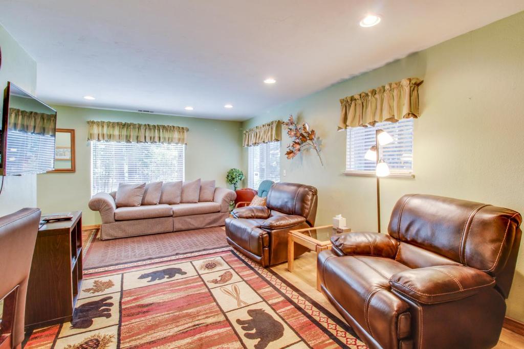 a living room with leather furniture and a television at Peaceful Pines Retreat in Mevers
