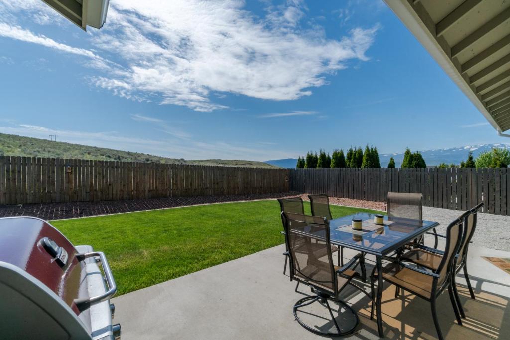 a patio with a table and chairs and a fence at East Wenatchee Serenity Hills in East Wenatchee Bench