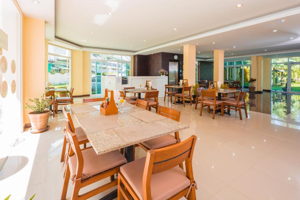 a dining room with tables and chairs in a restaurant at Sungthong Kamala Beach Resort in Kamala Beach