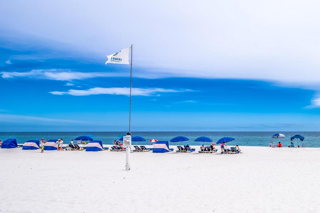 flaga na plaży z ludźmi siedzącymi pod parasolami w obiekcie Silver Beach w mieście Orange Beach