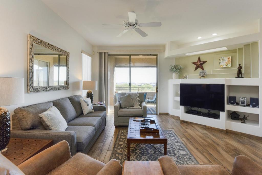 ein Wohnzimmer mit Sofa und Fernseher in der Unterkunft Vistoso Casitas Golf II #210B in Tortolita