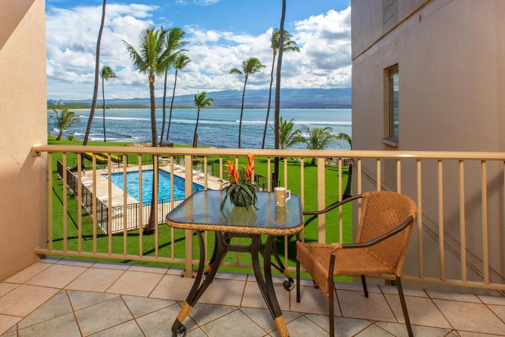 a balcony with a table and chairs and a pool at Maalaea Kai 305 in Maalaea