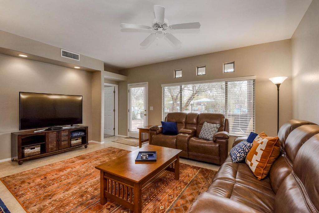 ein Wohnzimmer mit Ledermöbeln und einem Flachbild-TV in der Unterkunft Vistoso Resort Casita #165 in Tortolita