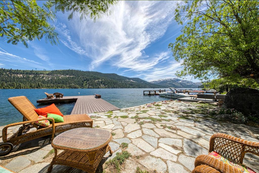 a patio with chairs and a table next to a lake at Lake Front Family Home at Donner in Truckee