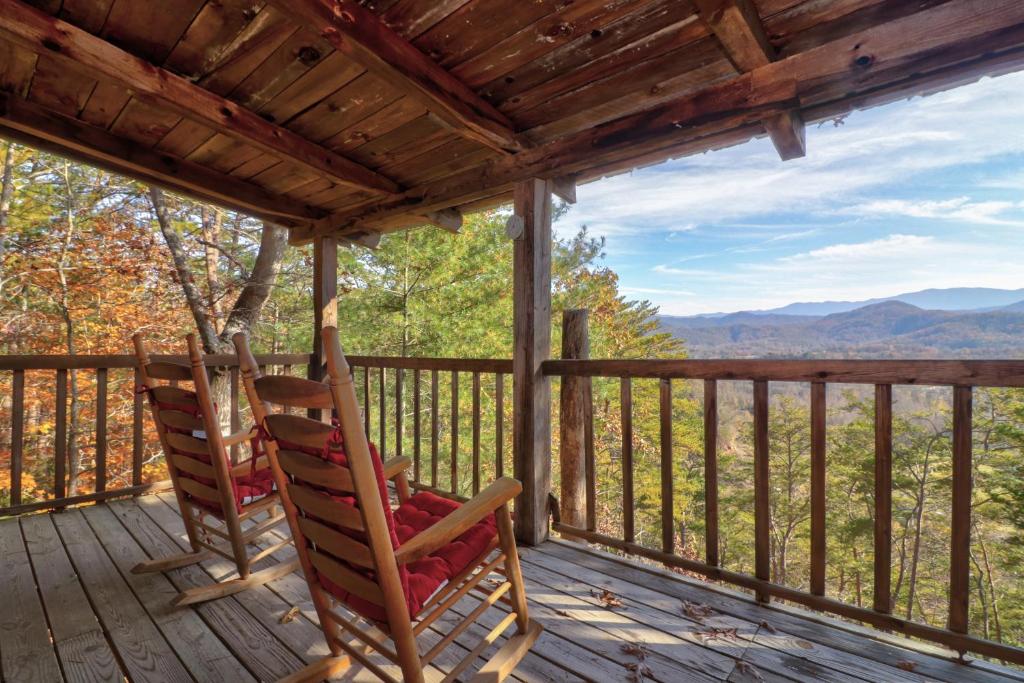 2 fauteuils à bascule sur la terrasse couverte d'une cabine dans l'établissement Treetop Tennessee, à Townsend