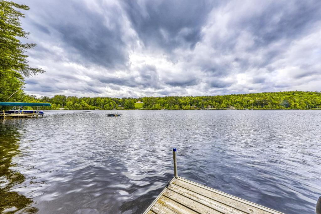 a dock on a lake with a boat on it at Basic Adirondack Camp in Chestertown